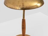 an image of a brass lamp with a wooden base on a white surface
