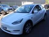 the white tesla model 3 is parked in a parking lot