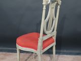 an image of a chair with a red seat on a carpeted floor