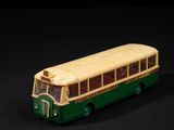 un petit bus en jouet posé sur une surface noire