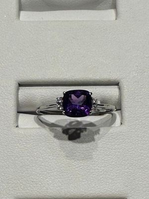 une bague sertie d'une pierre violette, dans un écrin