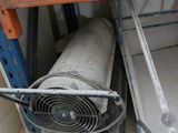 a fan sitting on top of a metal shelf in a room