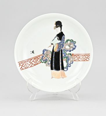 une assiette sur laquelle est représentée une femme en kimono