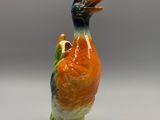 une figurine représentant un canard posée sur une surface blanche