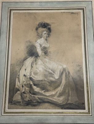 une vieille photo représentant une femme en robe blanche, assise sur une chaise