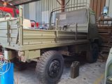 a green truck that is parked in a garage