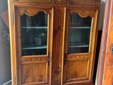 a wooden cabinet with glass doors and a clock on top of it
