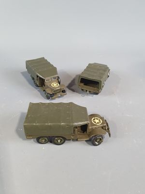 three toy army vehicles sitting on a white surface