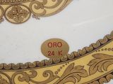 a close up of a decorative plate with a gold border