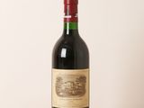 une bouteille de vin rouge posée sur une table en bois