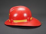 a red fireman ' s hat with a yellow band