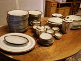 une table sur laquelle se trouvent beaucoup d'assiettes et de bols