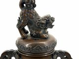 a bronze urn with a bird on top of it