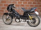 a black motorcycle parked in front of a brick wall