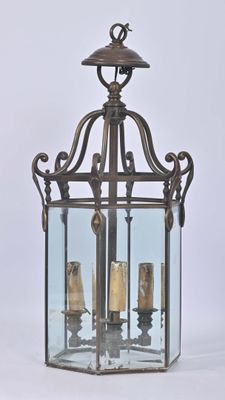 une lanterne à l'ancienne contenant trois bougies, sur fond blanc