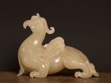 a white jade sculpture of a bird on a table
