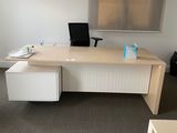 a desk with a chair and a laptop on it