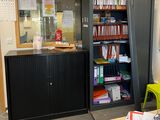 a desk with a bookcase and a chair in the corner