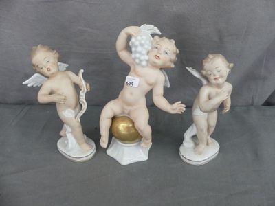 trois figurines de chérubins tenant une boule dorée