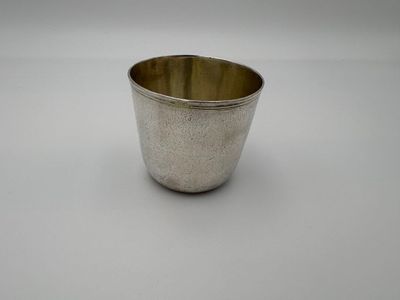an old silver cup on a white surface with a white background