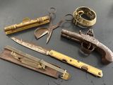 un pistolet, un couteau et d'autres objets posés sur une table