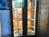 une photo d'un réfrigérateur à porte vitrée dans une pièce