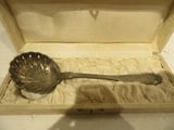 une cuillère en argent dans une boîte posée sur une table