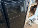 a black refrigerator in the corner of a kitchen