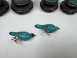 several pieces of blue and gold bird figurines on a white surface