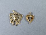 two pieces of gold plated metal with a butterfly and a heart