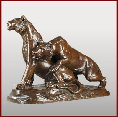 statue en bronze représentant un chien et un chat sur un rocher