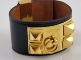 leather cuff bracelet with gold plated metal accents on a white surface