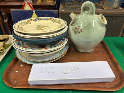 plusieurs assiettes et un vase posés sur un plateau, lui-même posé sur une table