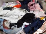 un gros tas de vêtements dans un panier posé par terre