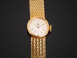 a close up of a gold wrist watch with a white dial