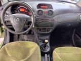the interior of a small car with a steering wheel and dashboard controls