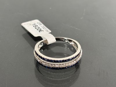 an image of a diamond and sapphire ring on a black surface