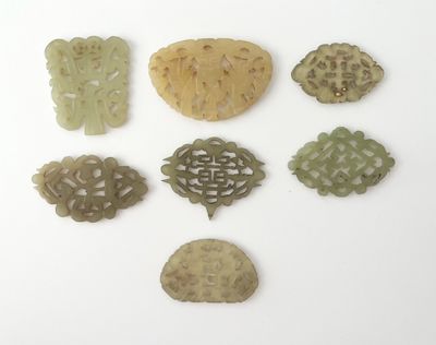 Plusieurs pièces de jade sculpté sont disposées ensemble sur une surface blanche