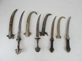 several knives are lined up on a white surface with a white background