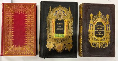 trois vieux livres sont alignés sur une surface blanche