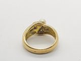 a close up of a gold ring with a pearl in it