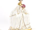 une figurine représentant une femme tenant une fleur