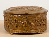 an image of a gold box with a scene on it on a table