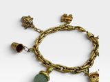 a close up of a gold bracelet with charms on it