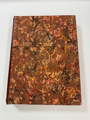 an image of a brown and red marbled book sitting on a white surface