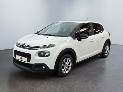Une Citroën blanche est garée dans une pièce blanche