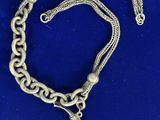 un collier en argent avec une breloque en forme d'ancre suspendue à une chaîne