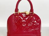 a close up of a red handbag on a table