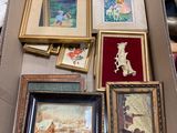 une boîte remplie d'œuvres d'art encadrées posée par terre