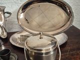 a silver plate with a silver lid on a wooden table